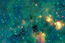 starfield with with blue stars and green, yellow and red clouds of gas
