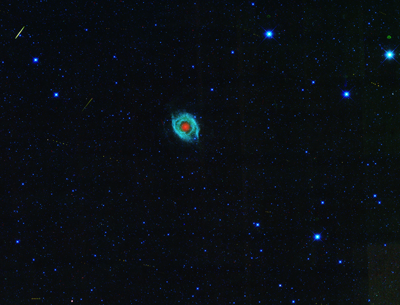 Red ball surrounded by greeen in the center of a star field.