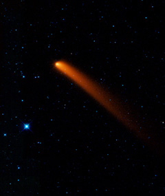 An orange streak across the sky shows the path of the comet Siding Spring.